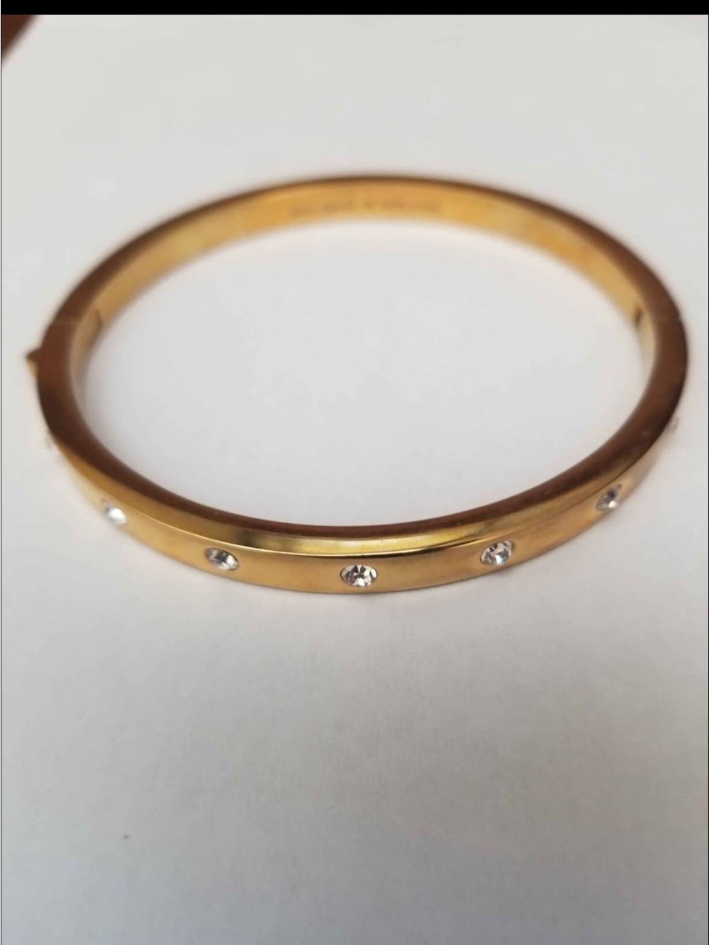 Kate Spade gold-tone hinged bangle featuring inset crystal accents